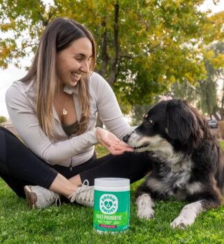 woman feeding doggie dailies probiotic treats to dog