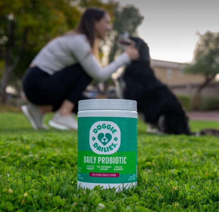 doggie dailies daily probiotic jar with dog and owner blurred in background